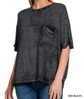 Woman wearing an oversized  acid wash black t-shirt with a pocket on a white background